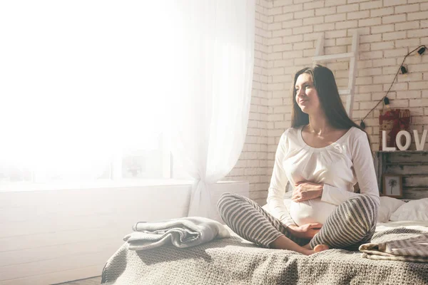 Hamile kadın yatakta.