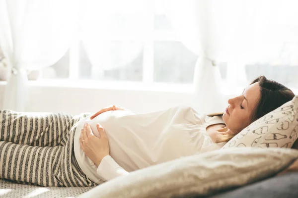 Těhotná žena v posteli — Stock fotografie