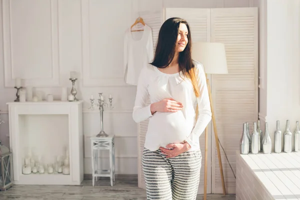 Gravid kvinna hemma promenader och hålla magen — Stockfoto