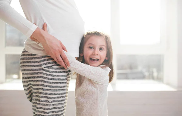 Беременная женщина и ребенок обнимаются — стоковое фото