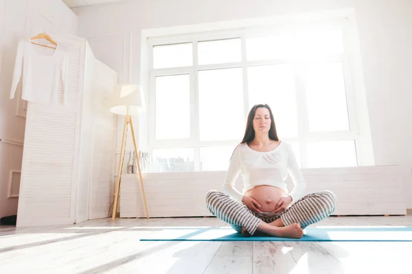 Mulher grávida fazendo ioga em casa — Fotografia de Stock