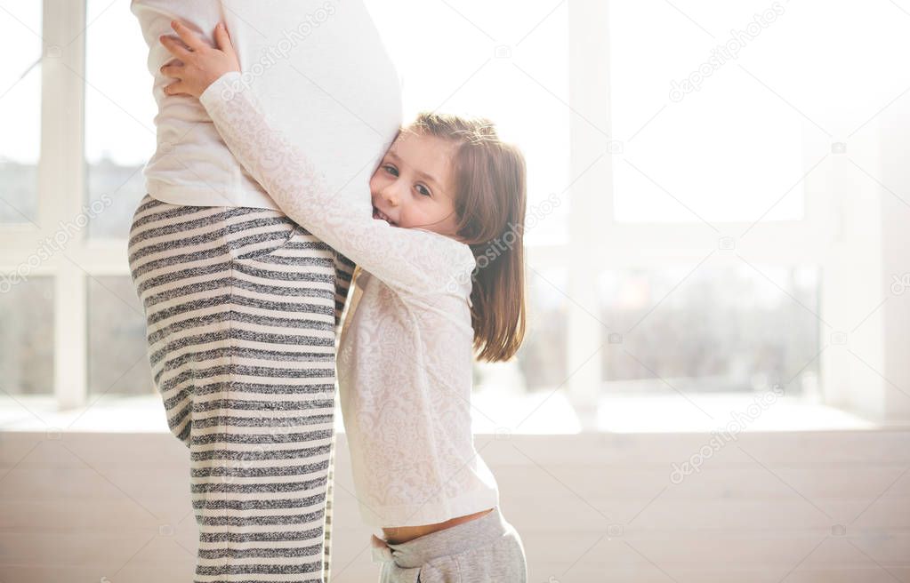 Pregnant woman and a child hugging