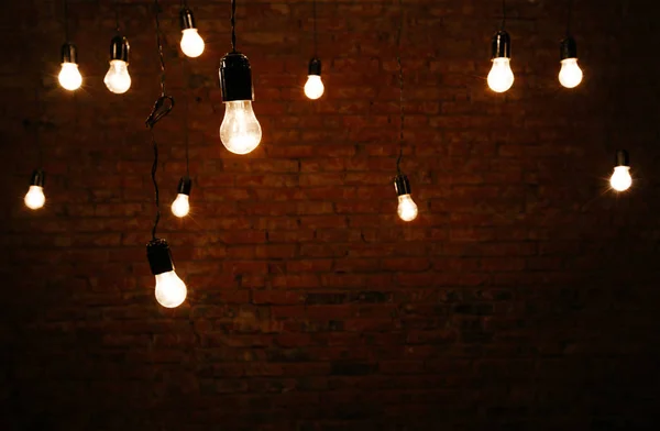 Light bulbs in interior over dark wall — Stock Photo, Image