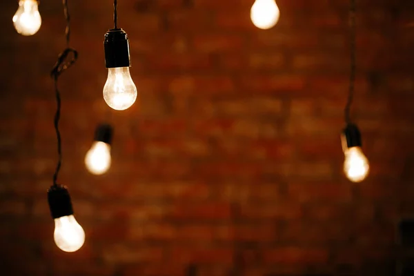 Light bulbs in interior over dark wall — Stock Photo, Image