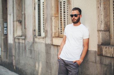 Rahat kentsel tarzı logo veya tasarım alanı olan beyaz boş t-shirt giyen sakallı hippi yakışıklı erkek modeli