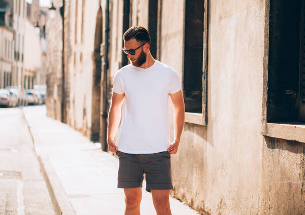 Хипстерская красивая мужская модель с бородой в белой футболке с пробелом для вашего логотипа или дизайна в стиле casual urban
