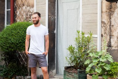 Rahat kentsel tarzı logo veya tasarım alanı olan beyaz boş t-shirt giyen sakallı hippi yakışıklı erkek modeli