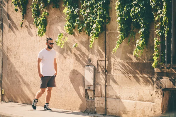 Modelo masculino bonito Hipster com barba vestindo t-shirt branca em branco com espaço para o seu logotipo ou design em estilo urbano casual — Fotografia de Stock