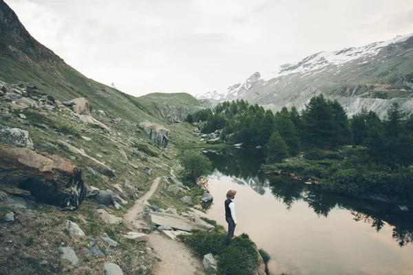 Muž s vousy nosit módní oblečení v horách, stojící — Stock fotografie