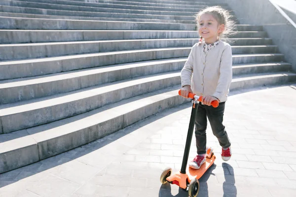 Şehirde scooter süren bir çocuk.