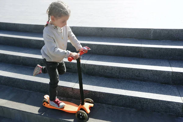 Kid riding a scooter in the city — Stock Photo, Image