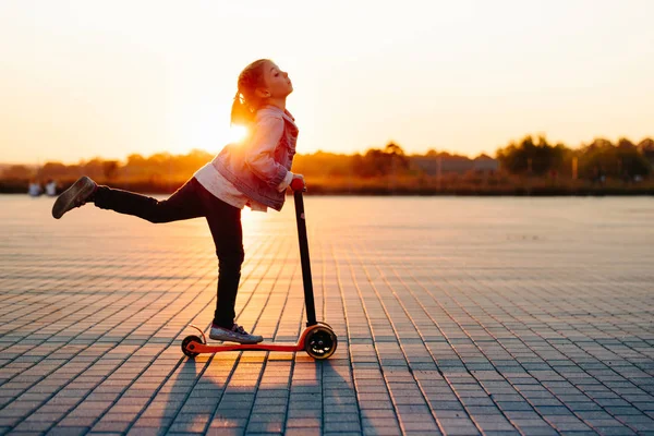 Menina montando uma scooter nas ruas da cidade — Fotografia de Stock