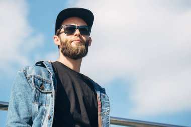 Güneş gözlüğü ve Siyah şapkası giyen bir şehirde hipster adam 