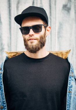 Modaya uygun kot elbise giyen gülümseyen yakışıklı hipster adam