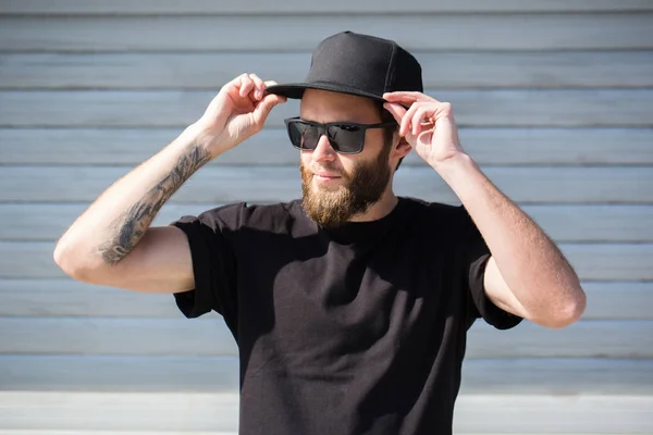 Hipster handsome male model with beard  wearing black blank  bas — Stock Photo, Image