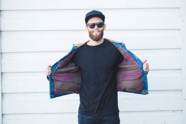 Gülümseyen ve siyah kot, tişört giyen eğleniyor hipster adam