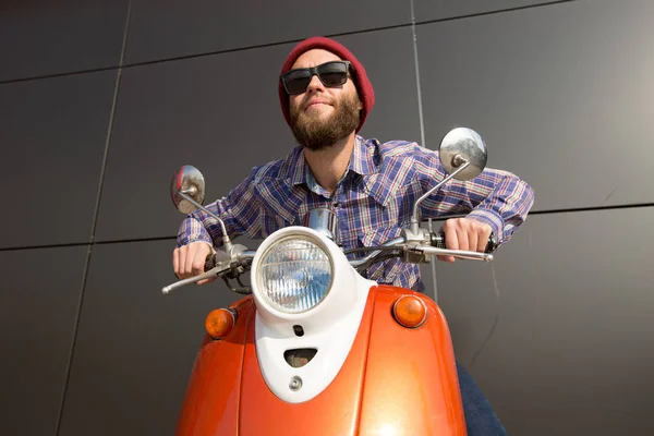 Hipster man riding a scooter riding with sunglasses — Stock Photo, Image