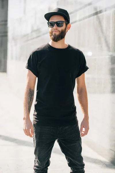 Hipster man walking na sobie czarne dżinsy i t-shirt baseball — Zdjęcie stockowe