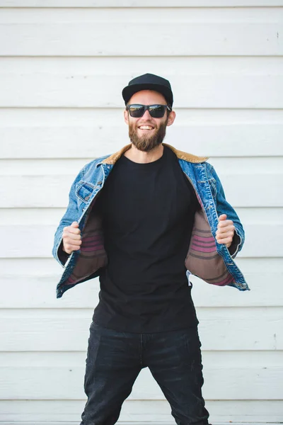 Hipster άνδρα με τα πόδια φορώντας μαύρο τζιν, t-shirt και ένα μπέιζ-μπώλ — Φωτογραφία Αρχείου