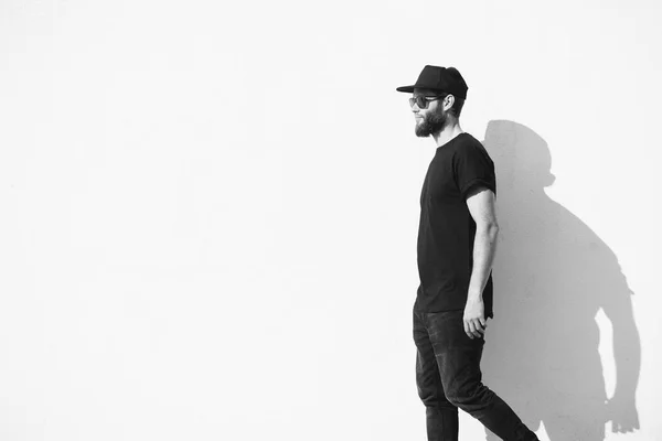 Hipster man walking along a wall wearing black clothes — Stock Photo, Image