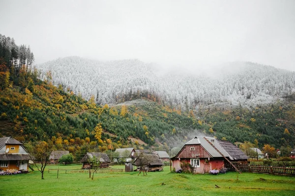 Hus i skogen med dimma och snö högt i bergen — Stockfoto