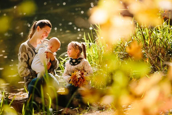Felice concetto di famiglia. Madre e bambini si divertono in autunno — Foto Stock