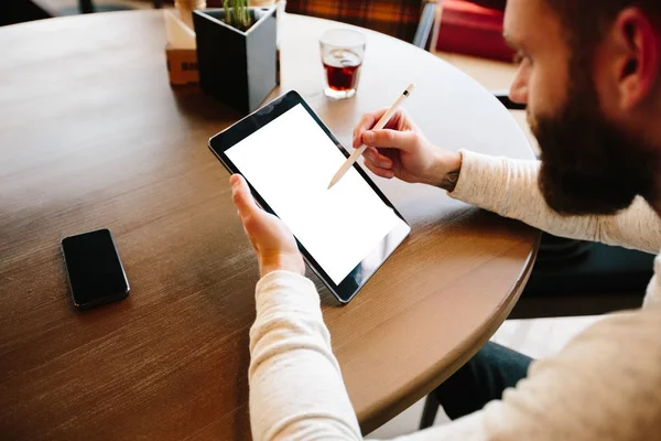 Mann benutzt Tablet-PC mit Bleistift am Schreibtisch — Stockfoto