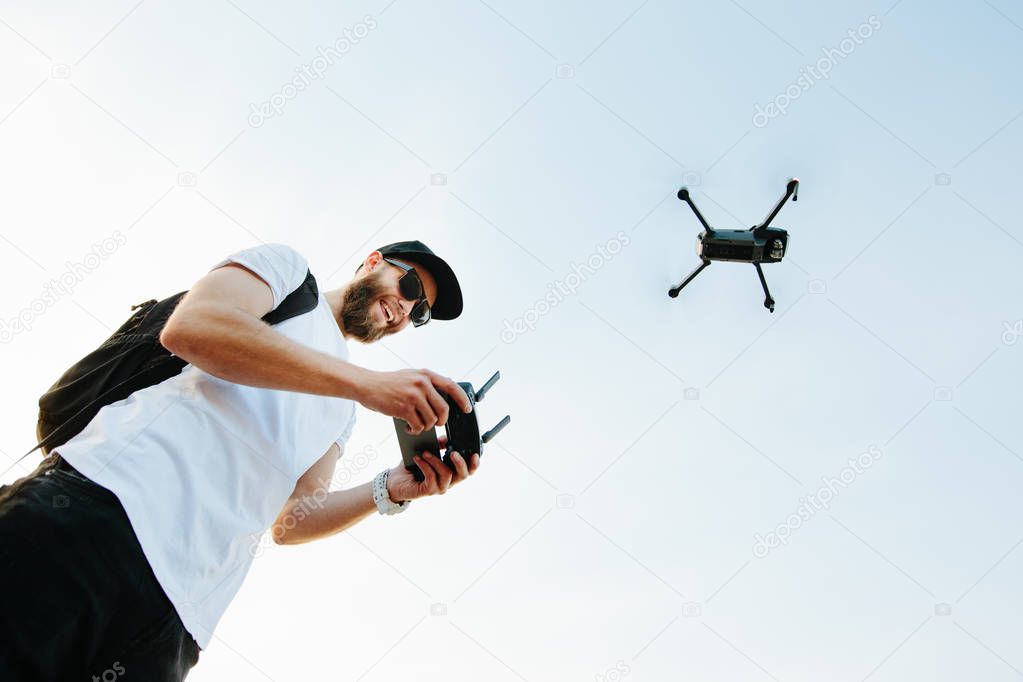 Man operating the drone by remote control and having fun 