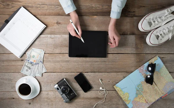 Mujer usando una tableta PC en el escritorio con un mapa del mundo y una co —  Fotos de Stock