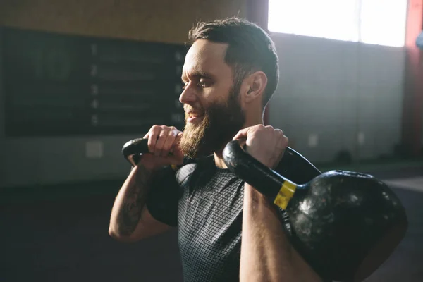 Homem atleta com barba exercitando-se em um ginásio crossfit — Fotografia de Stock