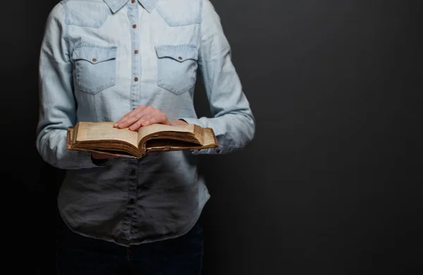 Femme lisant une vieille Bible sur un fond gris — Photo