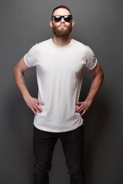 Hipster yakışıklı erkek model gri arka plan üzerinde logo veya tasarım alanı olan beyaz boş t-shirt giyen sakallı — Stok fotoğraf