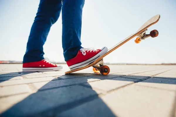 Skater et ses pieds sur une planche à roulettes — Photo