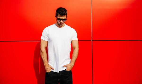 Fashion guy posing with white t-shirt with space for your logo — Stock Photo, Image