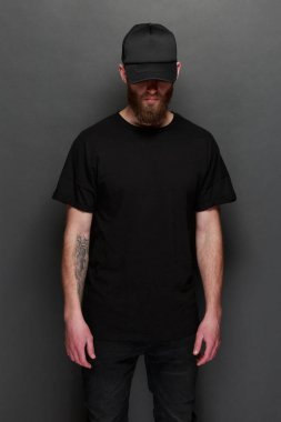 Hipster yakışıklı erkek model siyah boş tişört ve siyah beysbol şapkası için logo veya tasarım alanı ile rahat kentsel tarzı giymiş sakallı