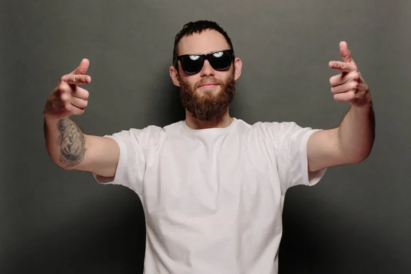 Hipster knappe mannelijke model met baard met witte witte witte t-shirt en een honkbalpet met ruimte voor uw logo of ontwerp in casual stedelijke stijl — Stockfoto