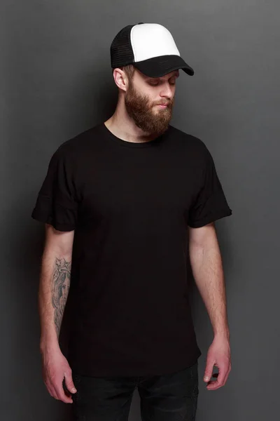 Hipster άνδρα με τα πόδια φορώντας μαύρο τζιν, t-shirt και ένα άσπρο μπέιζ-μπώλ ΚΑΠ — Φωτογραφία Αρχείου