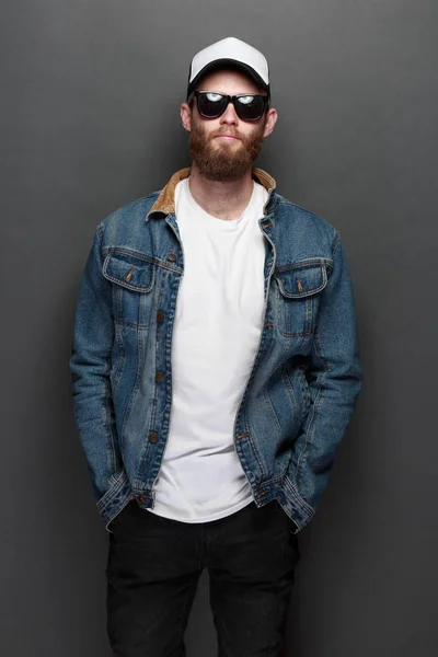 Hipster stilig manlig modell med skägg bär vit blank t-shirt och en baseball mössa med plats för din logotyp eller design i avslappnad urban stil — Stockfoto