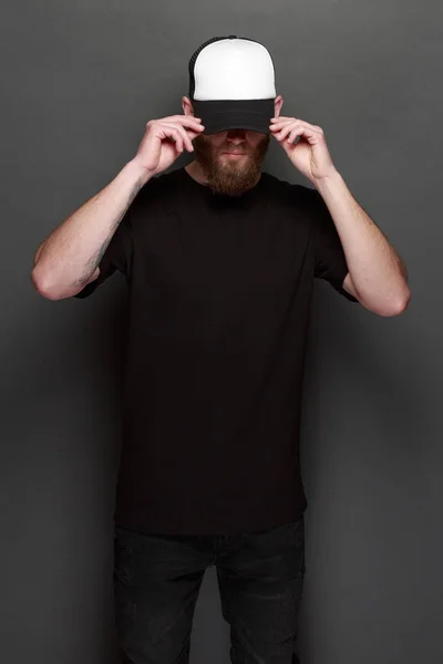 Hipster man walking na sobie czarne dżinsy, t-shirt i czapkę z daszkiem biała — Zdjęcie stockowe
