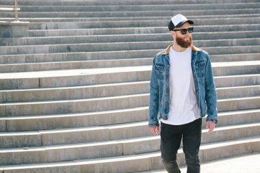 Siyah kot, tişört ve bir beyzbol yürüyen hipster adam 