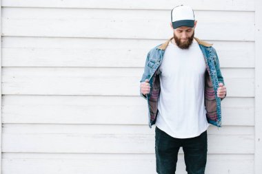 Sakallı, beyaz, boş tişörtlü, beysbol şapkalı, logonuz için yeri olan yakışıklı bir hippi mankeni.