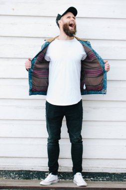 Sakallı, beyaz, boş tişörtlü, beysbol şapkalı, logonuz için yeri olan yakışıklı bir hippi mankeni.