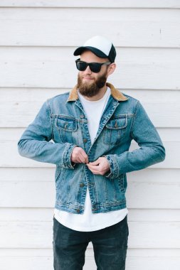 Sakallı, beyaz, boş tişörtlü, beysbol şapkalı, logonuz için yeri olan yakışıklı bir hippi mankeni.