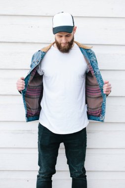 Sakallı, beyaz, boş tişörtlü, beysbol şapkalı, logonuz için yeri olan yakışıklı bir hippi mankeni.