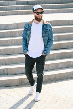 Sakallı, beyaz, boş tişörtlü, beysbol şapkalı, logonuz için yeri olan yakışıklı bir hippi mankeni.