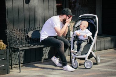 Babası bir bebek arabası ve bir bebek şehir sokaklarında yürüyüş