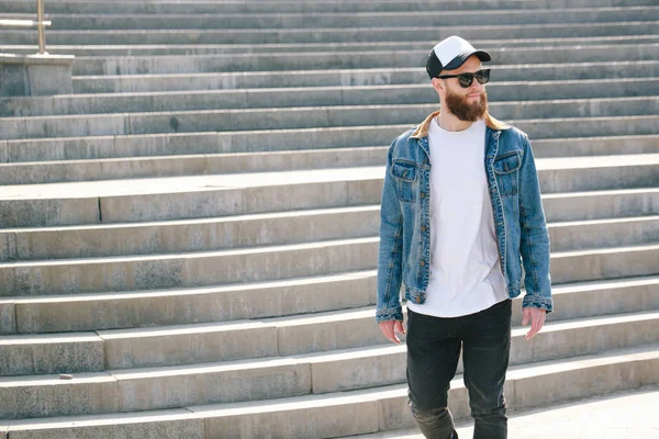 Hipster man walking wearing black jeans, t-shirt and a baseball — Stock Photo, Image