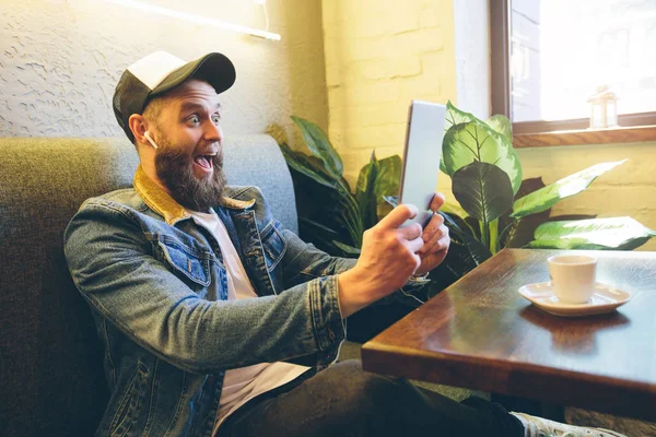 Hipster man med sport in-ear trådlös hörlurar Lyssna på m — Stockfoto