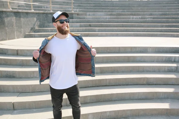 Hipster gutaussehendes männliches Model mit Bart trägt weißes Blank-T-Shirt und Baseballmütze mit Platz für Ihr Logo oder Design im lässigen urbanen Stil — Stockfoto