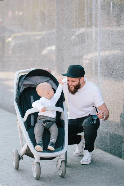 Father walking with a stroller and a baby in the city streets — Stock Photo, Image